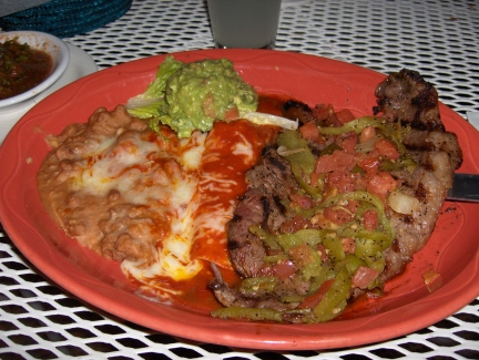 Tampiquea steak with a red enchilada and guacamole