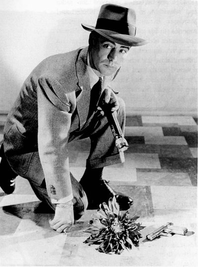 Alan Ladd in a goofy studio shot with a blue dahlia Alan Ladd in a goofy studio shot with a blue dahlia