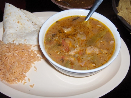 Lucy's caldillo served in a bowl with rice and tortilla on the side
