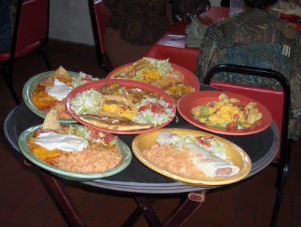 Plates of food are just about to reach a large group of hungry patrons